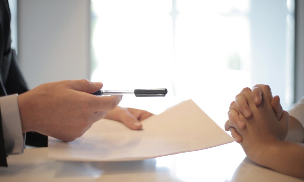 crop businessman giving contract to woman to sign